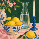 Schilderij van een stilleven met citroenen in een blauw-witte kom, een glazen karaf, een blauwe kaarsenstandaard en roze bloesem.