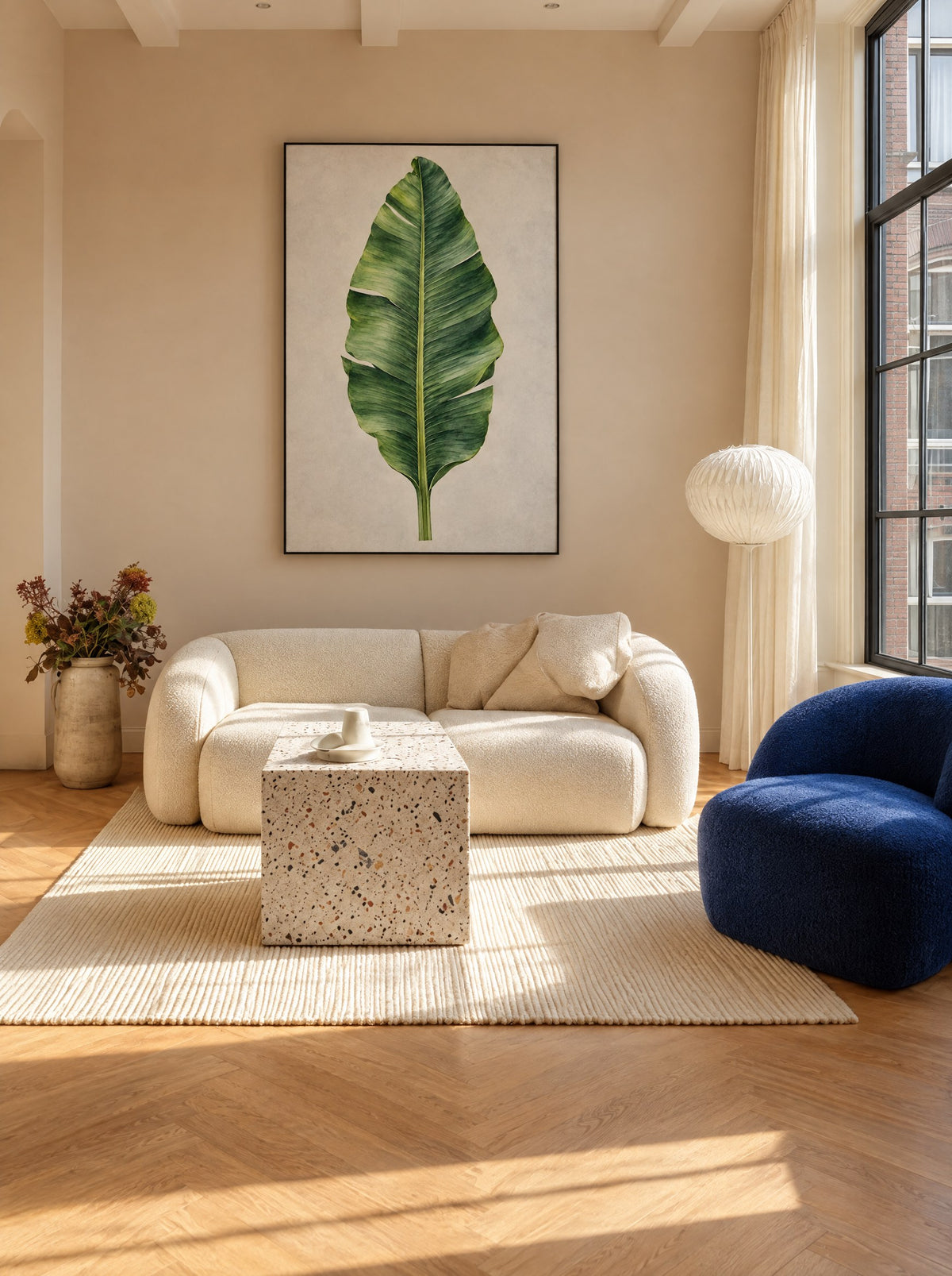Bananenblad in een zwarte lijst, aan de muur in een frisse woonkamer met planten.