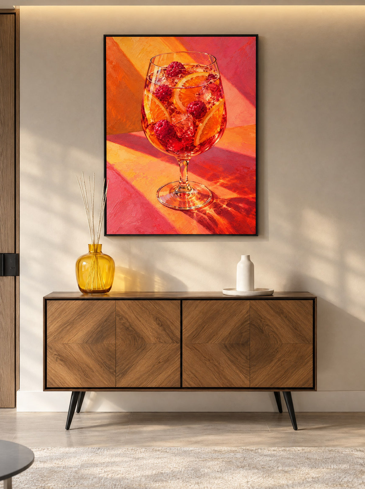 Schilderij met cocktail in een zwarte lijst, aan de muur in een gezellige eetkamer.