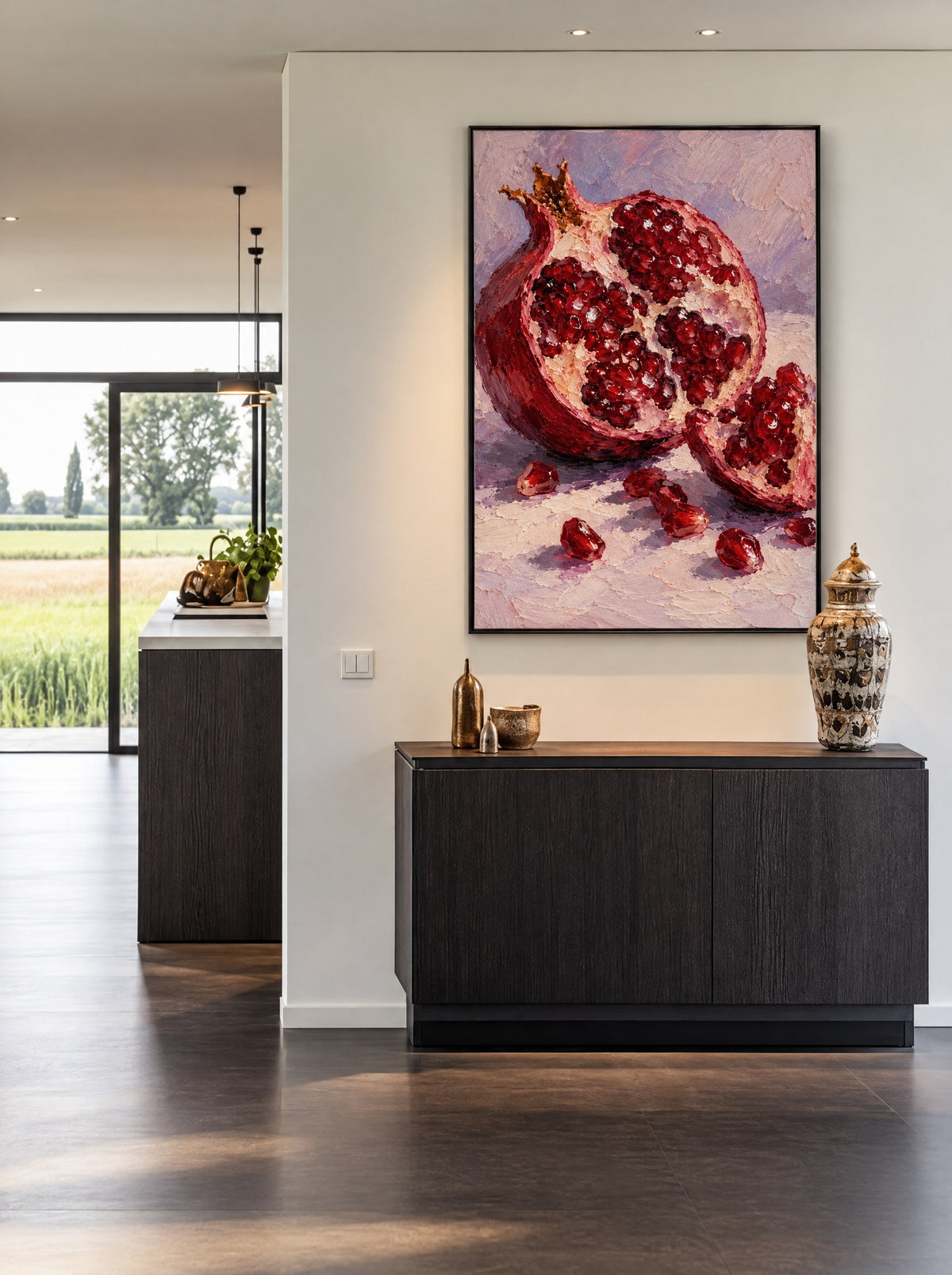 Schilderij met granaatappel in een zwarte lijst, aan de muur in een moderne eetkamer.