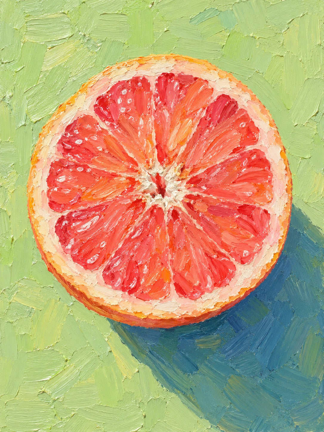Doorgesneden roze grapefruit van bovenaf op een lichtgroene achtergrond met een blauwe schaduw.