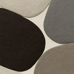 Rounded stone shapes in relief in espresso brown, mineral grey, taupe and bone on cream
