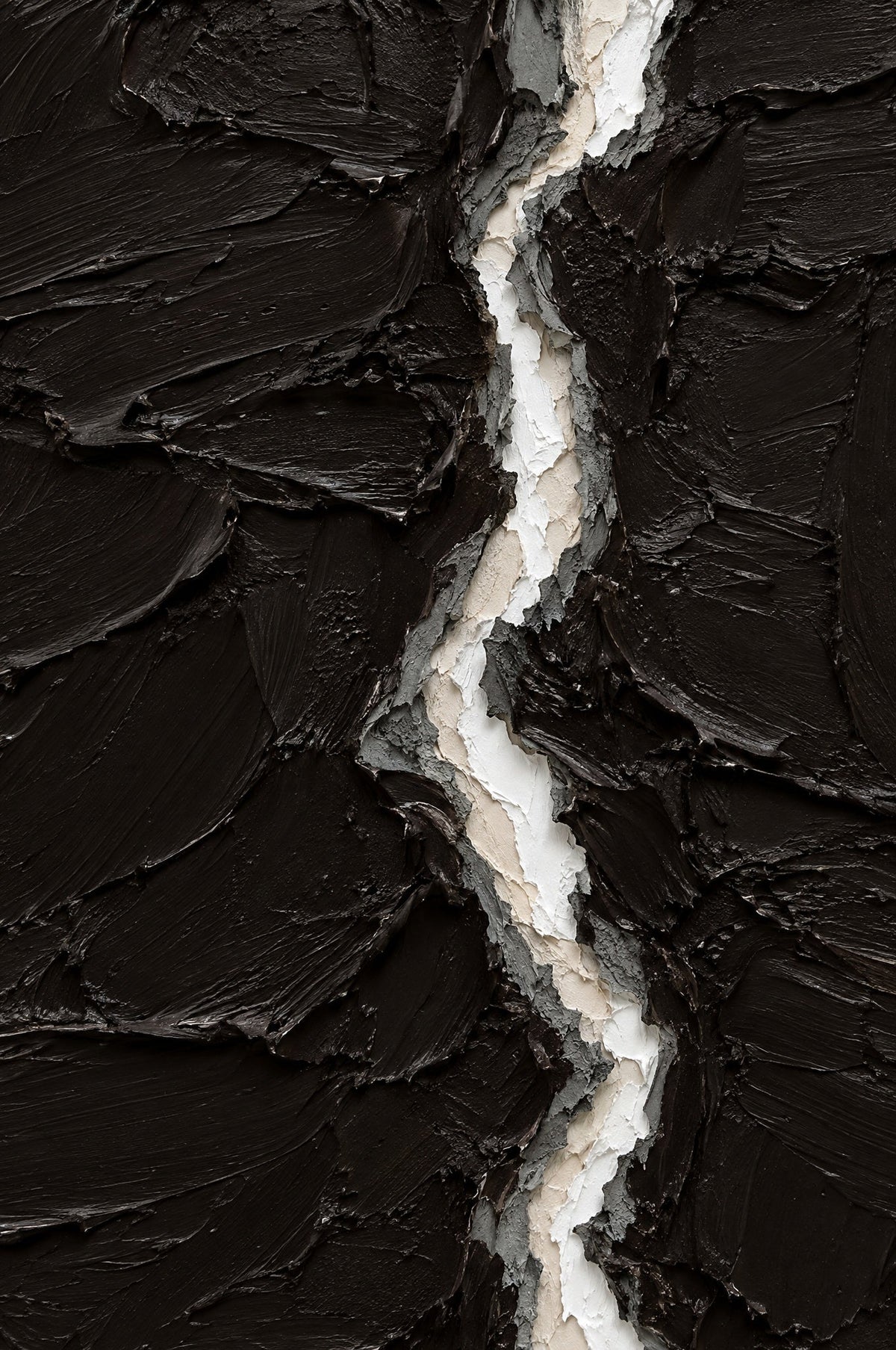 Abstract reliëfwerk in dik zwartbruin met een verticale breuk in wit, crème en grijs